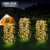 Three strands of warm white LED willow lights illuminate a grassy outdoor scene near a tent.