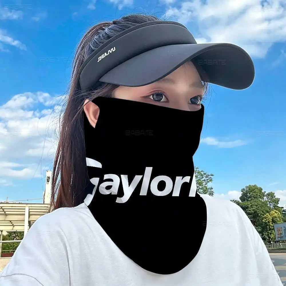 A person wearing a black neck gaiter and a gray cap outdoors under a blue sky.