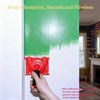 A hand is using a red paint edger brush to apply green latex paint on a white wall.