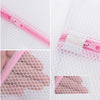 Close-up view of a pink mesh laundry bag with a zipper and elastic closure for delicate clothing care
