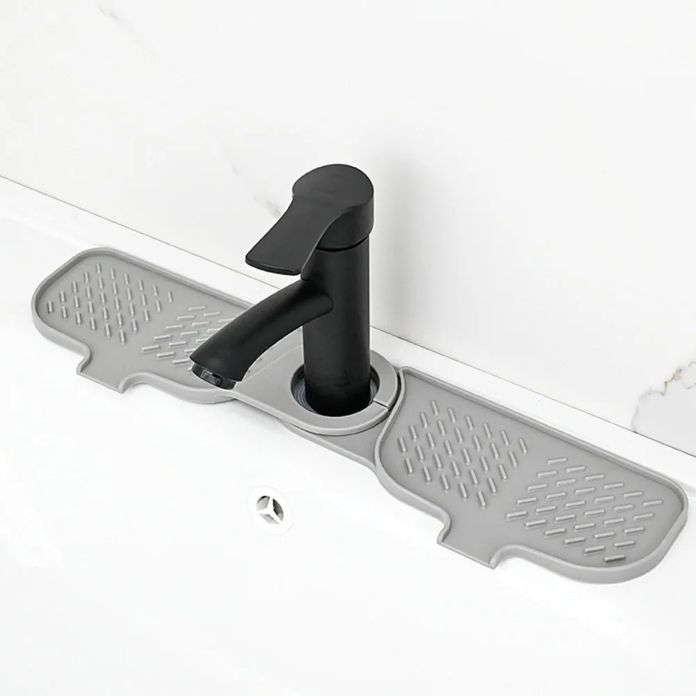 A black silicone sink faucet mat with a rotatable splash guard mounted on a white countertop.