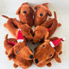 A set of five brown plush cartoon dog slippers with red and white noses lying on a white surface.