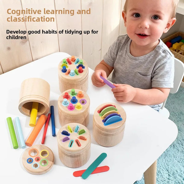 A baby is playing with wooden color sorting toys, including cylinders and discs, for cognitive learning and fine motor skills