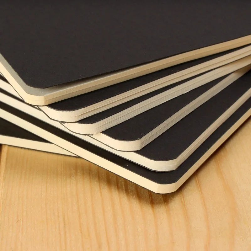 A stack of black and white A6 kraft paper blank notebooks for sketching and journaling