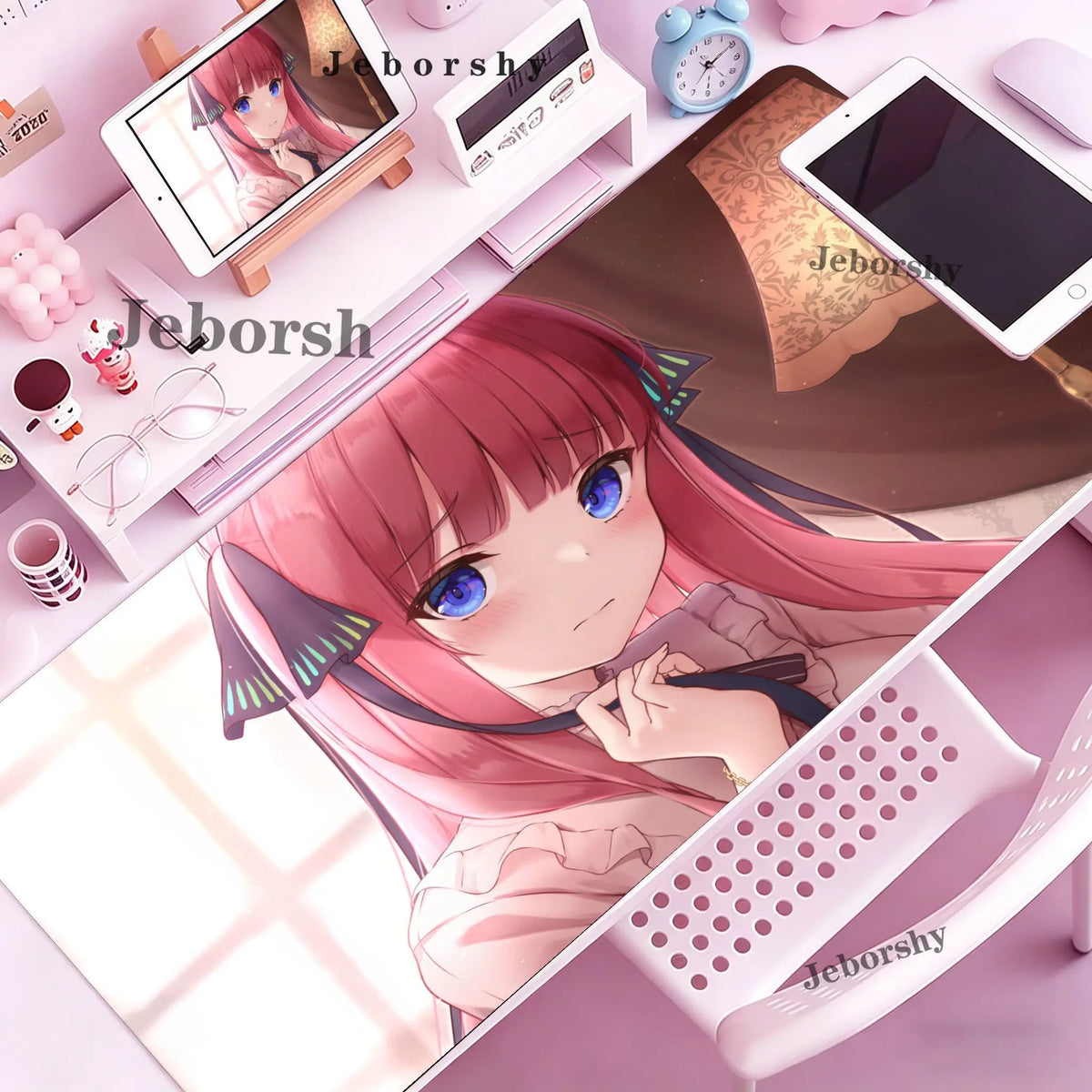 A close-up of a pink-haired anime girl character displayed on a mouse pad or desk mat with various accessories.