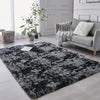 Dunkelgrauer und schwarzer Plüsch-Tie-Dye-Teppich in einem modernen Wohnzimmer mit einem Sofa.