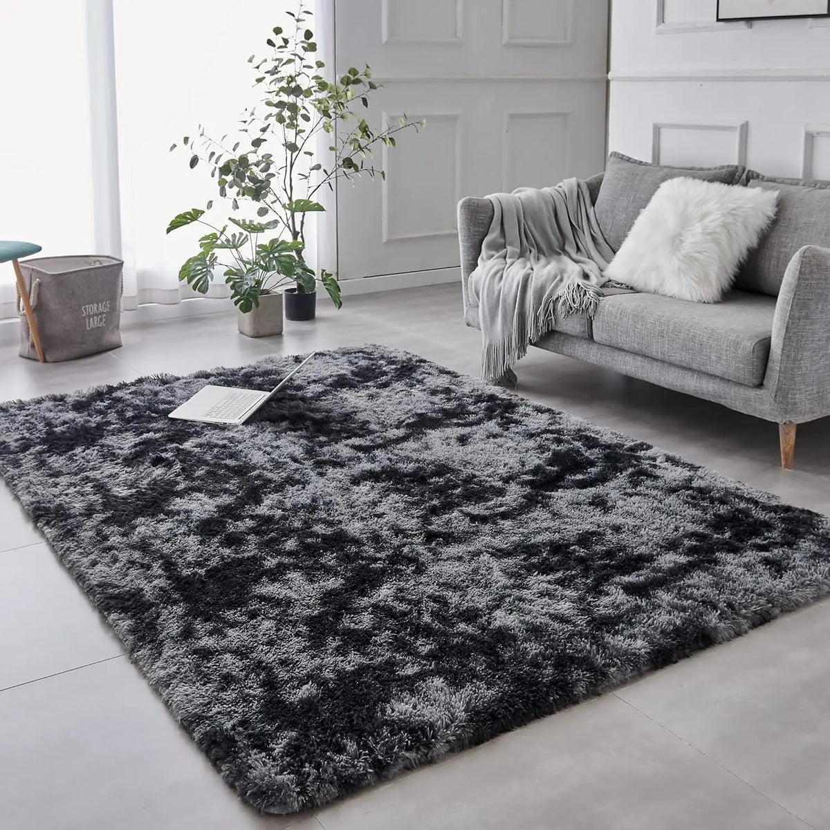 Dunkelgrauer und schwarzer Plüsch-Tie-Dye-Teppich in einem modernen Wohnzimmer mit einem Sofa.