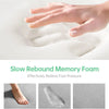 A hand presses into a white memory foam mat, demonstrating its slow rebound and pressure relief for feet.