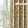 A close-up of a beige blackout curtain panel featuring a red and green plant pattern.
