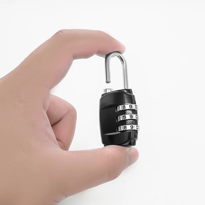 A hand holds a black secure multi-dial combination lock with a silver key ring.