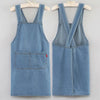 A light blue denim cross-back apron displayed on a hanger.