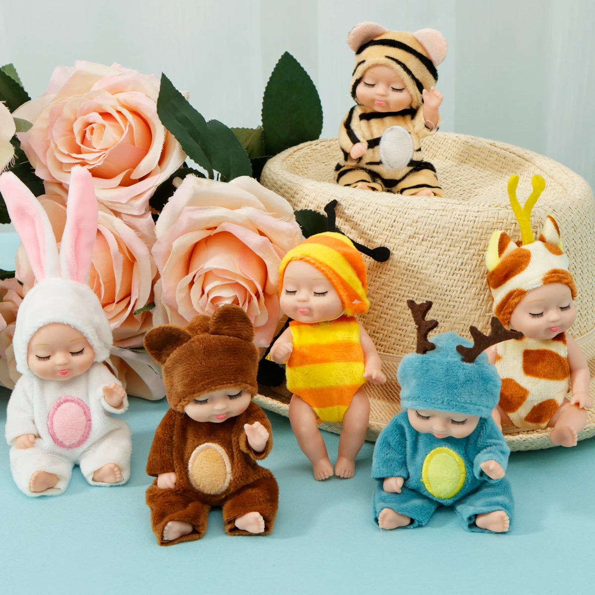 A collection of mini reborn baby dolls with various outfits and accessories, including a tiger, a bunny, and a bear.