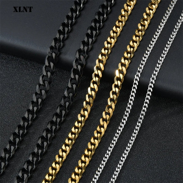 Primer plano de cuatro collares de eslabones cubanos de acero inoxidable en acabados negro, dorado y plateado.