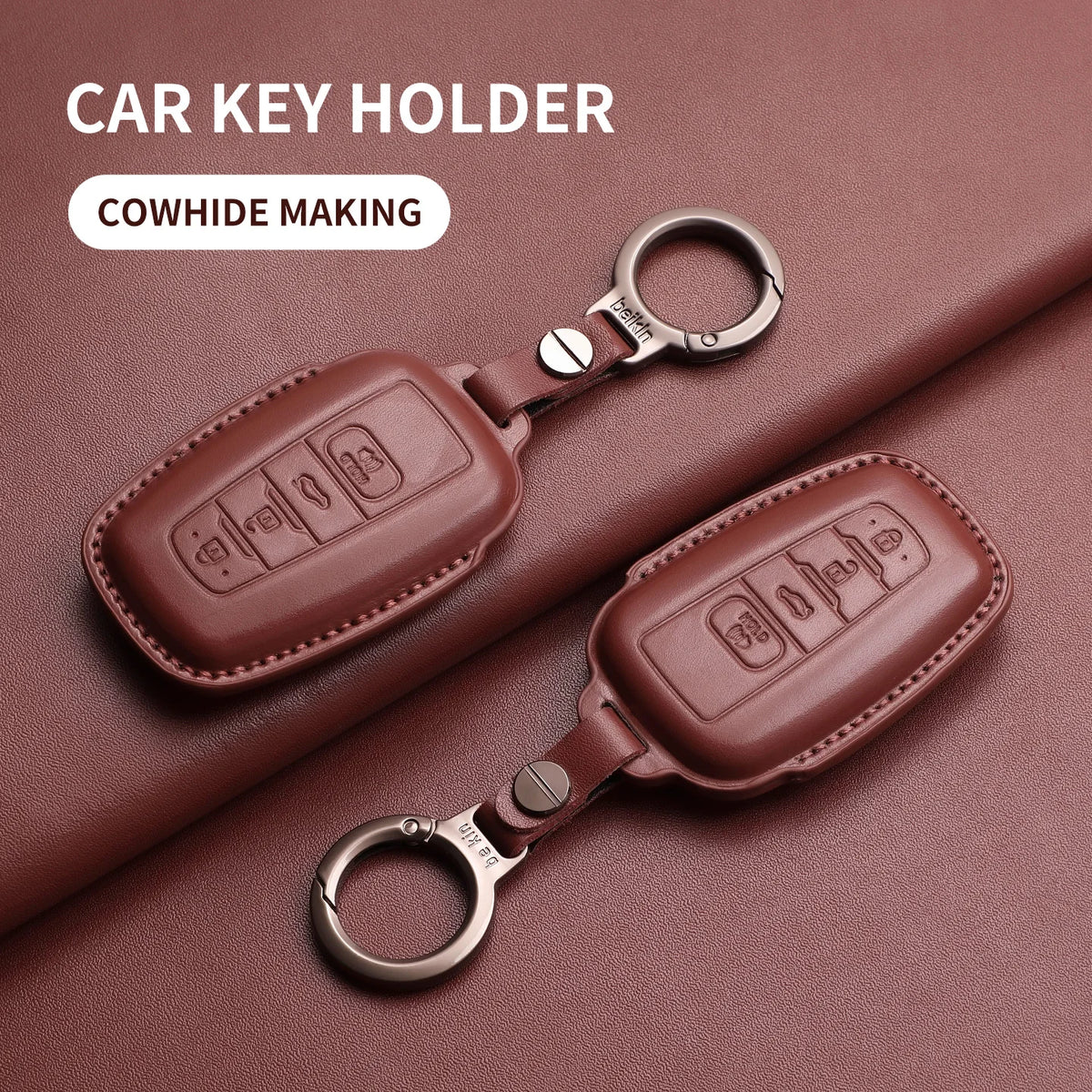 A brown genuine leather car key holder with a metal ring, shown on a dark pink background.