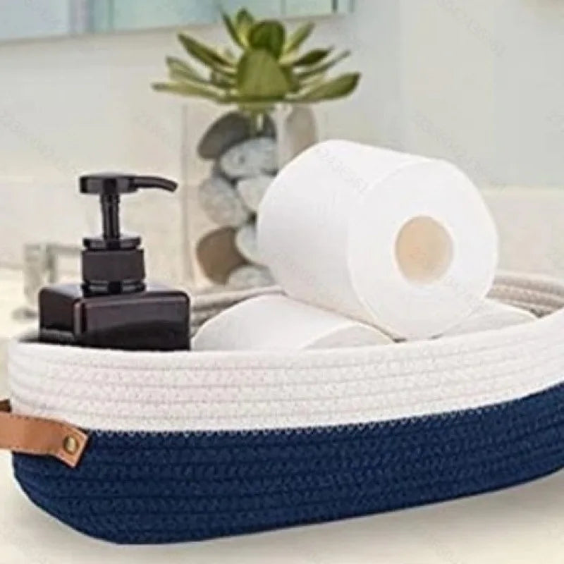 A navy blue woven cotton rope storage basket holding a roll of white paper towels.