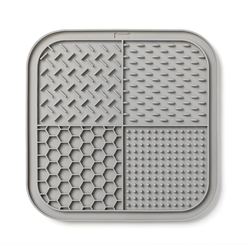 A gray silicone lick mat for dogs and cats with suction cups, featuring textured patterns.