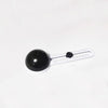 A black circular object with a white scale and markings, likely an adjustable paper cutter.