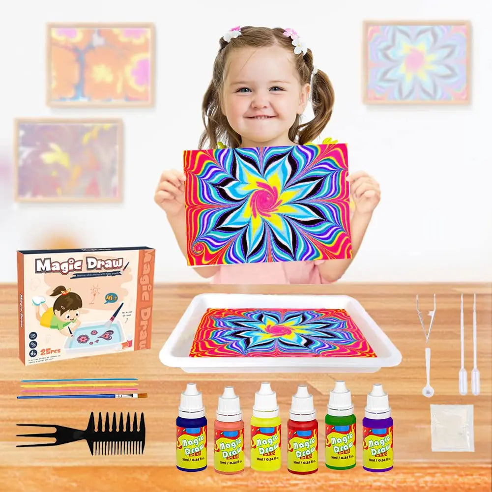 A smiling girl holds a colorful magic draw painting kit with various supplies and a finished fluid art design on a tray.