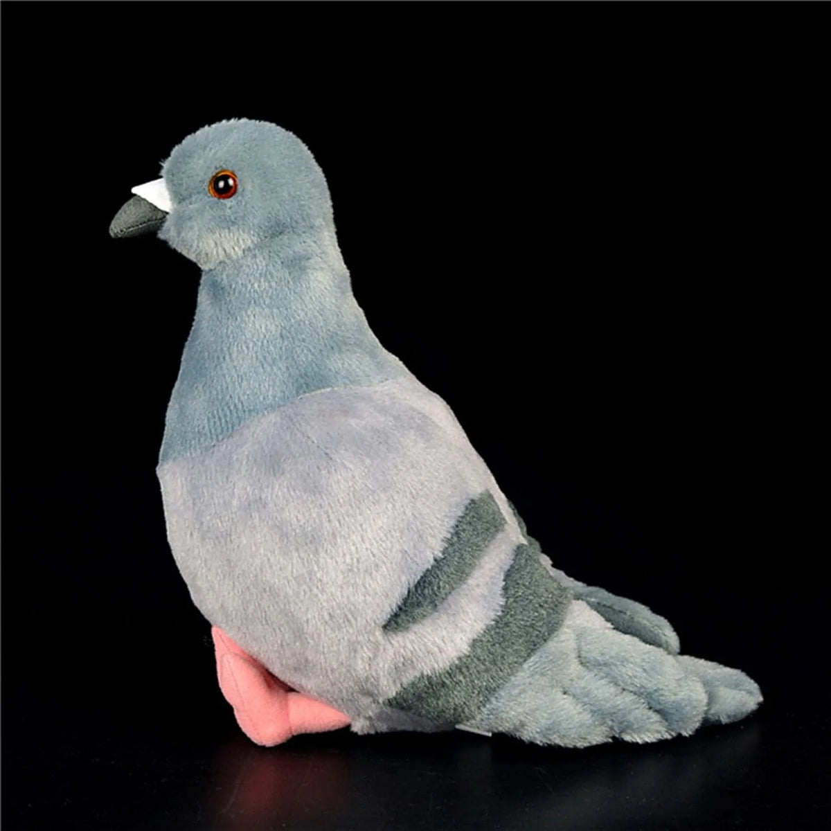 A soft gray plush toy of a pigeon with a pink underside is shown against a black background.