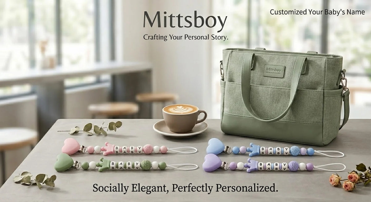 A green baby pacifier clip with a custom name is displayed on a wooden table next to various natural greenery.