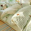 A light green and white checkered duvet cover set with matching pillow shams displayed on a bed.