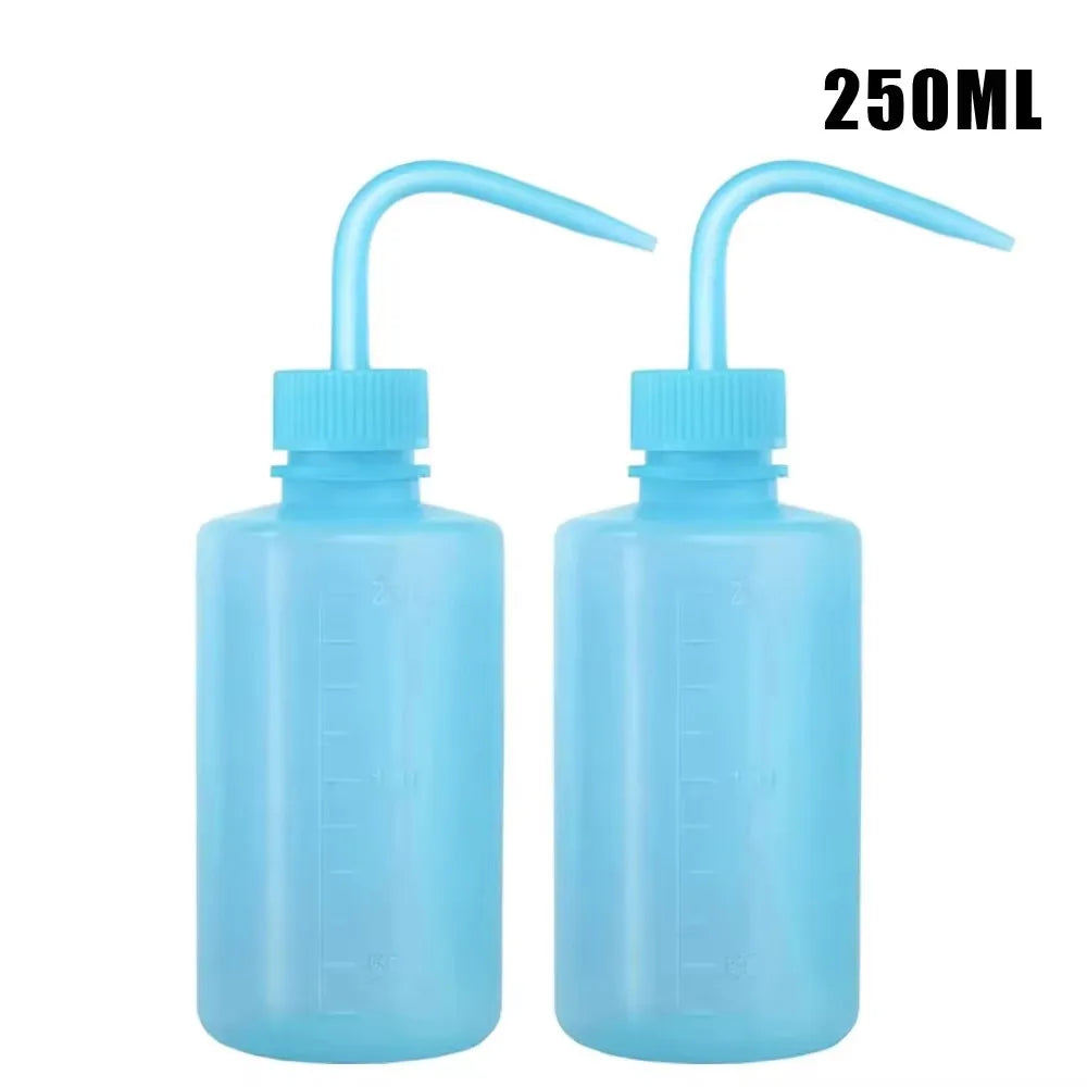 Two clear blue squeeze bottles with long tips for tattoo ink or liquid application