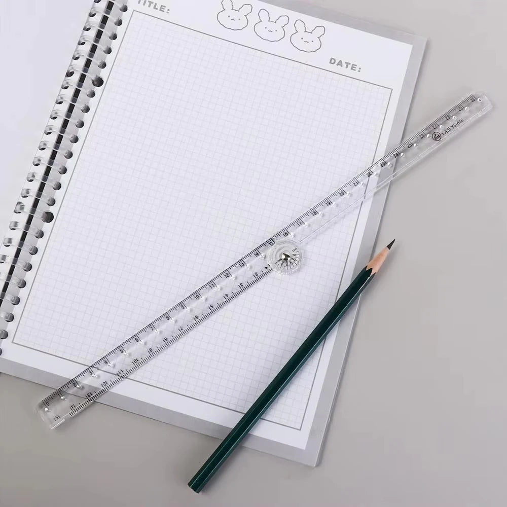 A transparent plastic ruler is placed diagonally across a spiral notebook with a grid, next to a dark pencil.