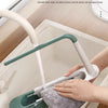 A hand is using an adjustable over-sink dish drying rack to clean a sink, demonstrating smooth inner corners and no dead corn
