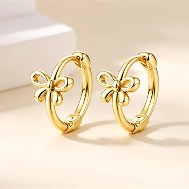 Par de aretes de aro dorados con un dije floral.