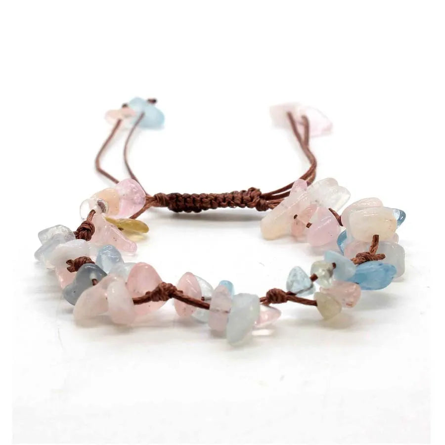 A set of braided crystal chip stone bracelets featuring pink, blue, and clear translucent stones on brown macrame cord.