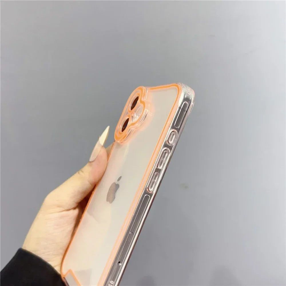 A hand holds an iPhone in a clear glow-in-the-dark neon orange case against a light gray background.