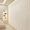A vertical pleated white fabric room divider curtain with hooks in a modern interior setting.