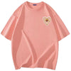 A light peach t-shirt featuring a heart-shaped rhinestone patch design on the chest.