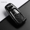 A black carbon fiber style key fob cover for an Audi, shown in a close-up view.