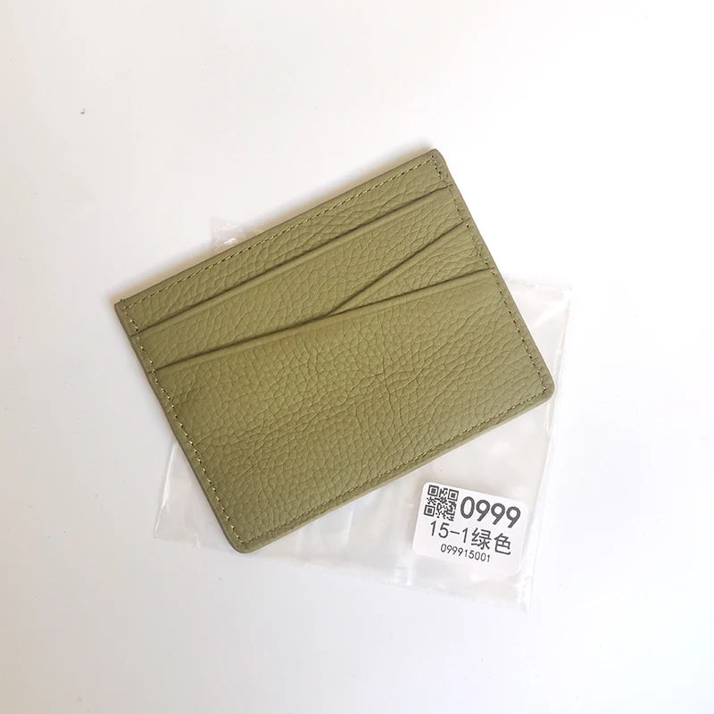 A slim card holder wallet made of olive green genuine leather, packaged in a clear plastic sleeve.