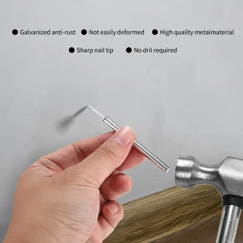 A hand is holding a silver double head wood nail kit, demonstrating its sharp tip and ease of use.