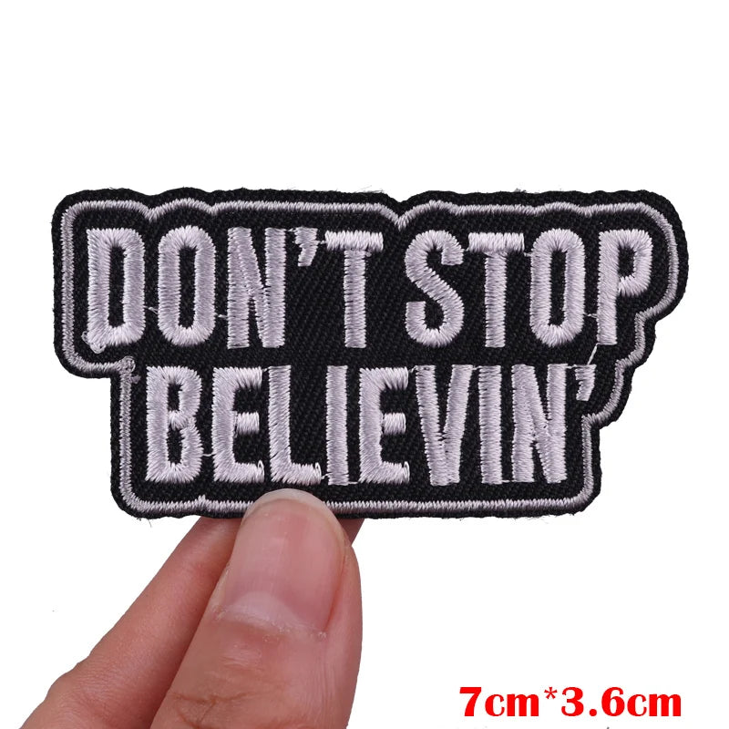Black embroidered iron-on letter patch with white text that reads DON'T STOP BELIEVIN'