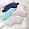 A collection of silk sleep masks in various colors including navy blue, light blue, pink, and white, displayed on a white bac