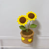 Handcrafted crochet sunflower with green leaves growing in a brown crocheted pot