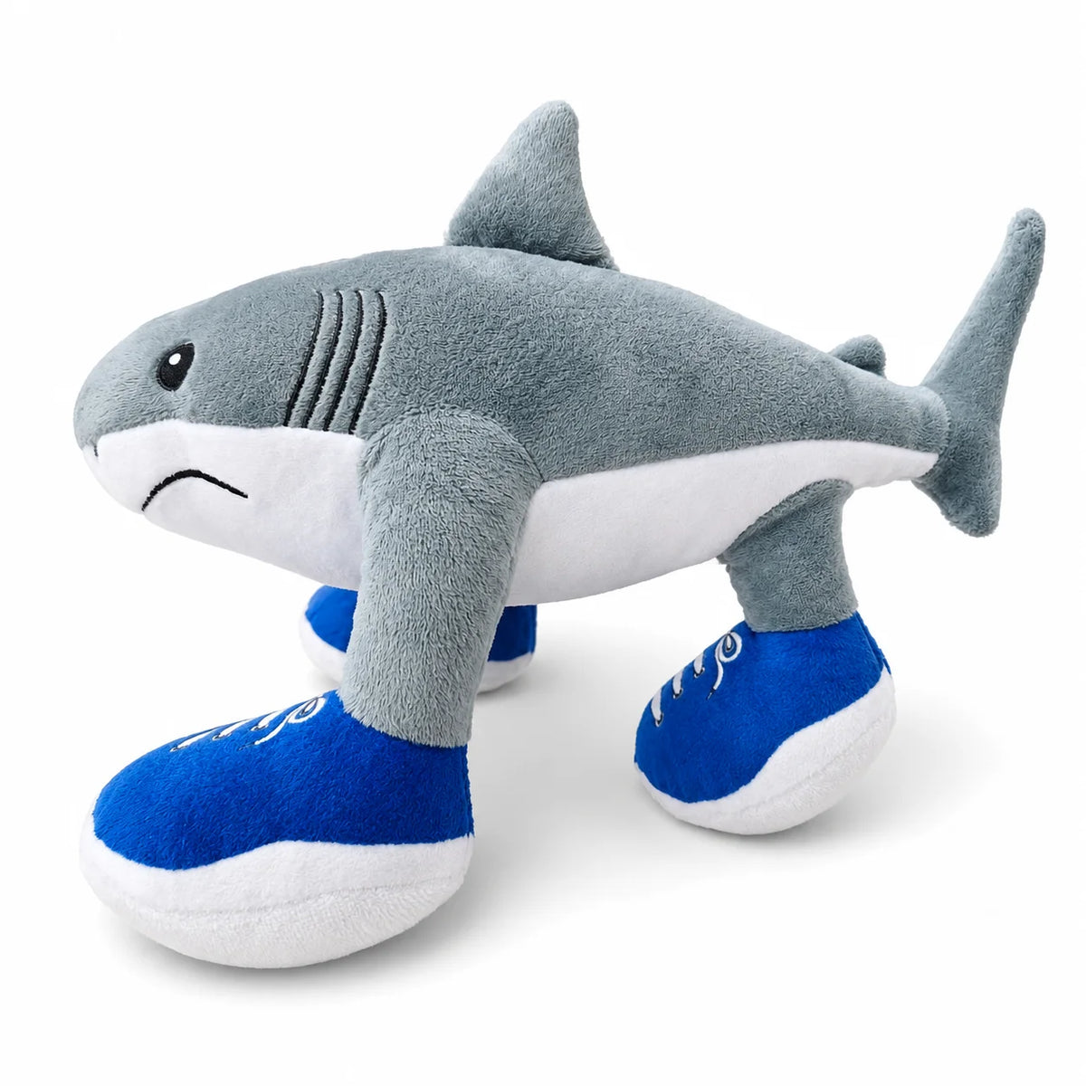 A gray and white plush toy shaped like a shark wearing blue shoes.