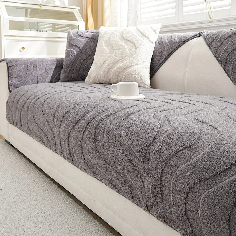 Funda de cojín gris texturizado con una almohada y una taza blanca encima.