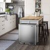 A stainless steel dual compartment recycling trash can with a soft-close lid sits on a dark wood floor in a kitchen setting.