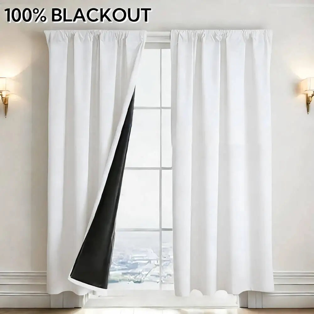White blackout curtain panels hanging in a window frame