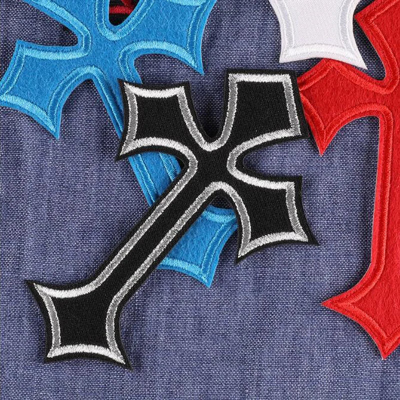 A set of ten vibrant embroidered cross patches in blue, red, and black on a denim fabric background.