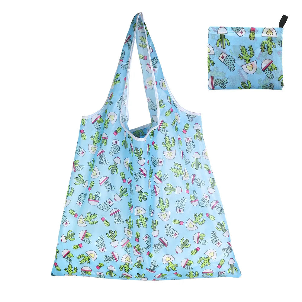 A light blue reusable shopping tote filled with various fruit and vegetable patterns.