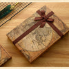 A vintage leather-bound map or document is shown on a wooden surface, tied with a brown ribbon, next to a metal grid and anot