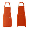 A bright orange waterproof canvas chef apron hanging against a white background.