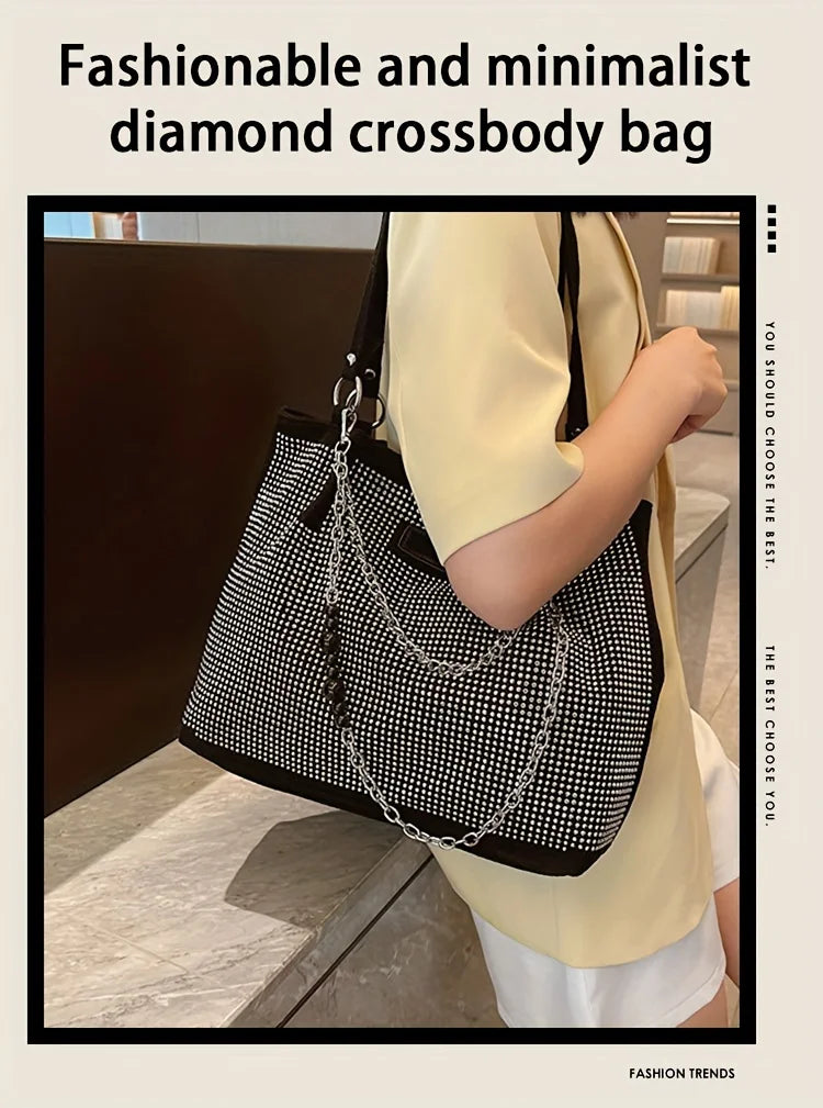 A woman holds a black diamond crossbody bag with a silver chain against a light yellow shirt.