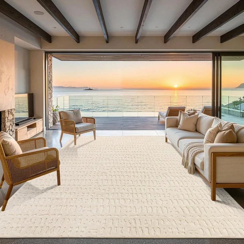 A large cream cowhide print area rug in a modern Western style placed in an indoor living space with large glass doors overlo