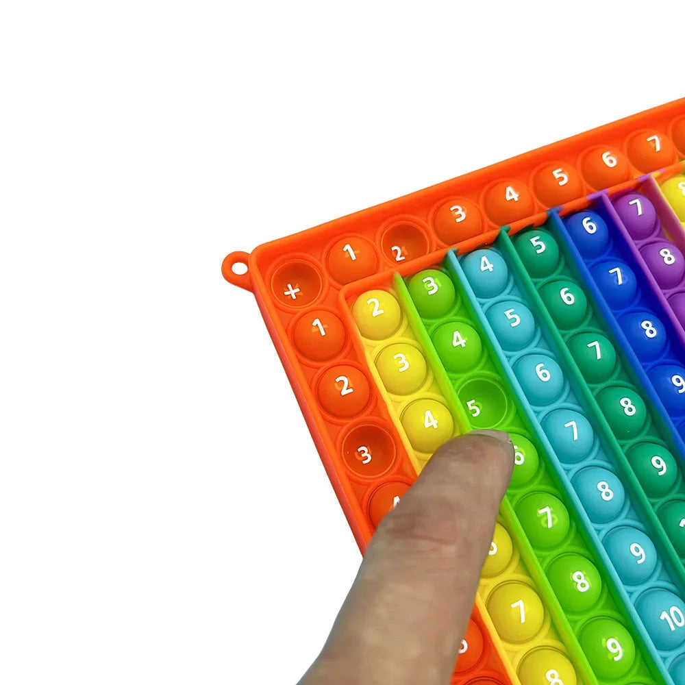 Eine Hand interagiert mit einem orangefarbenen Plastik-Puzzlebrett mit nummerierten farbigen Steinen zum Mathematiktraining.